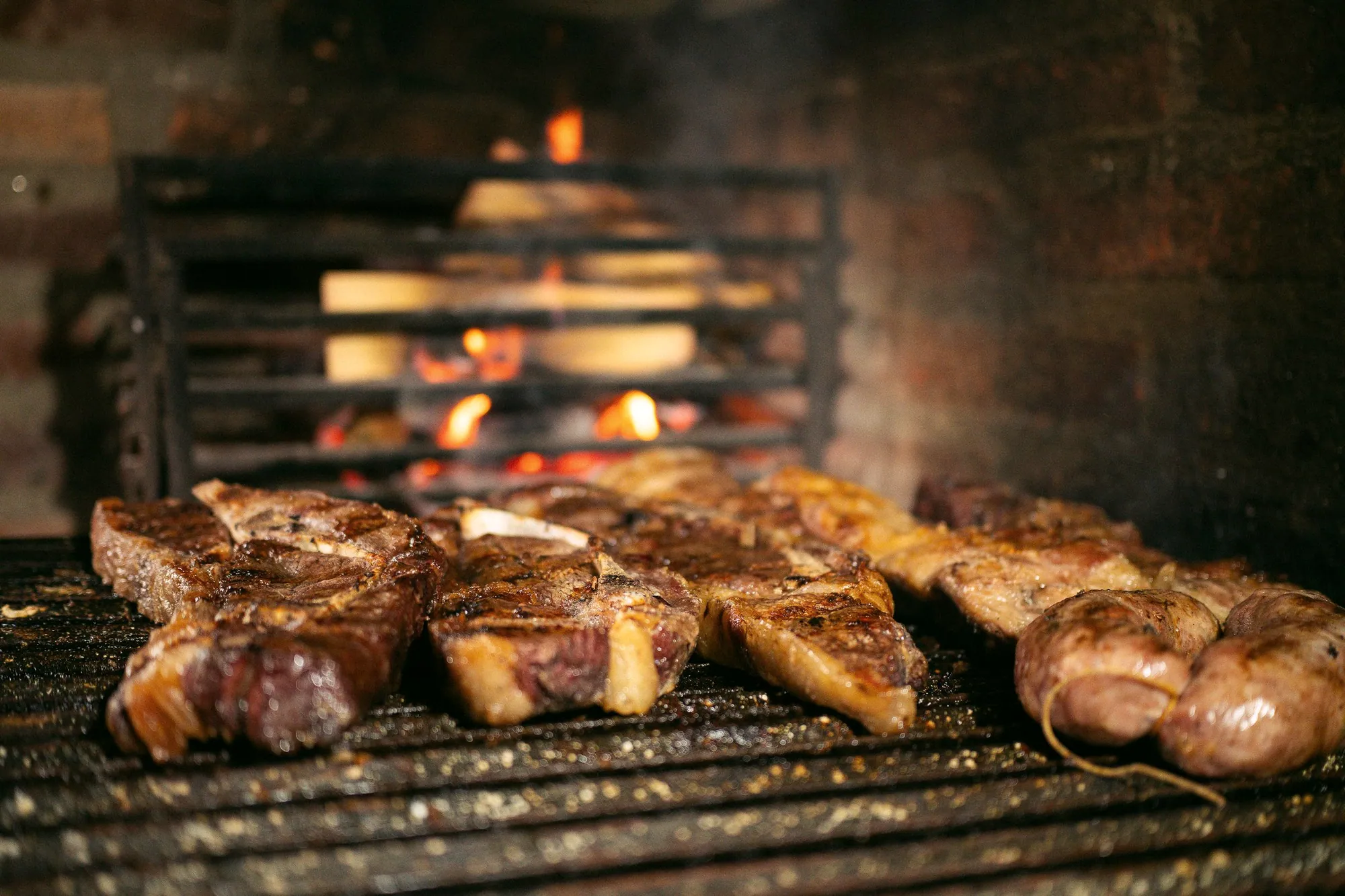 Meat cooking over an open fire on a barbecue grill